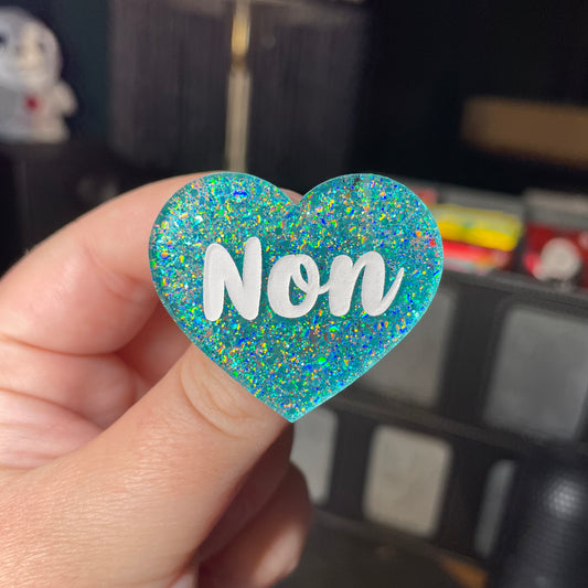Broche "Non" en acrylique à paillettes turquoise