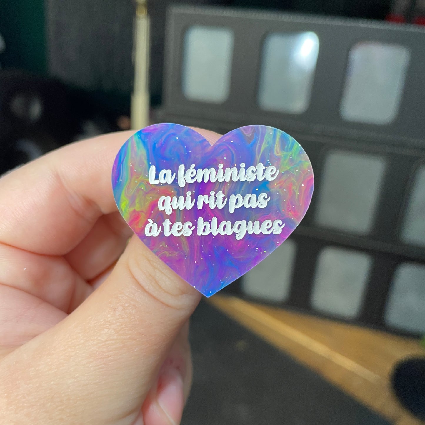 Broche "La féministe qui rit pas à tes blagues" en acrylique semi transparente marbrée multicolore