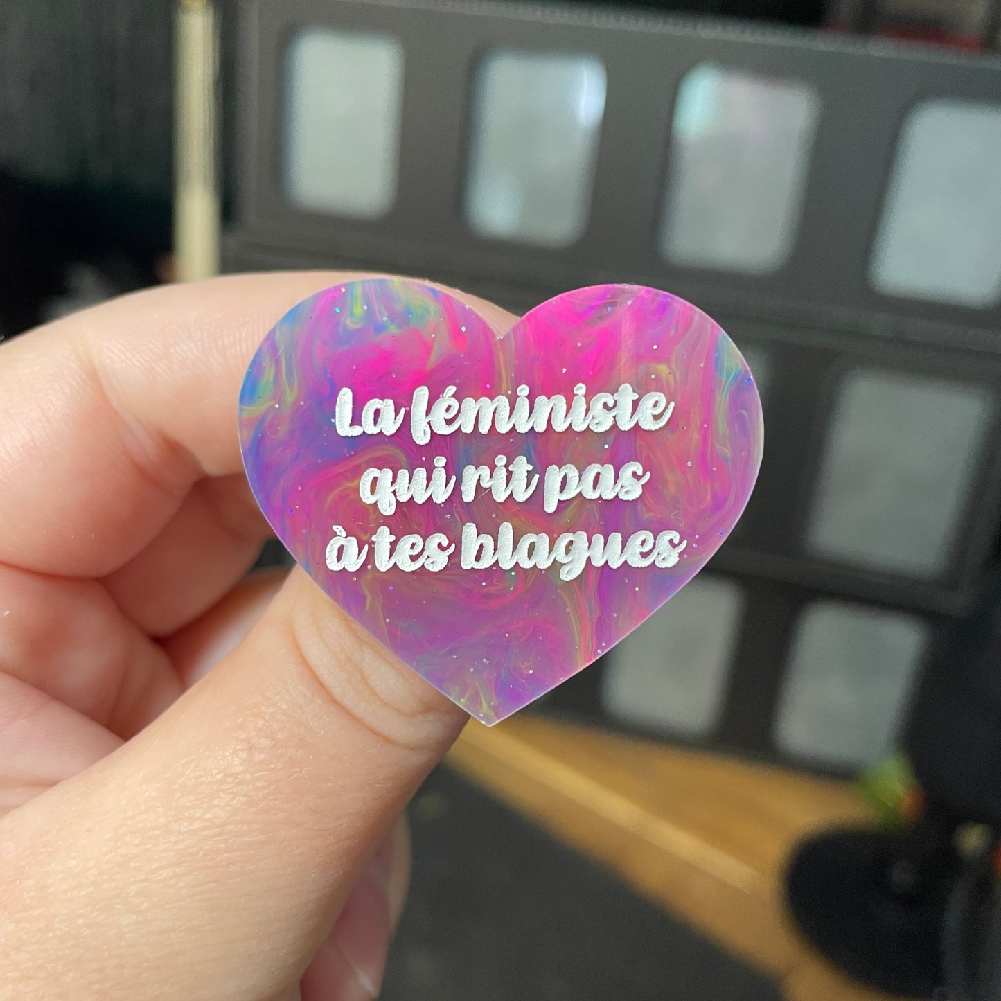 Broche "La féministe qui rit pas à tes blagues" en acrylique semi transparente marbrée multicolore