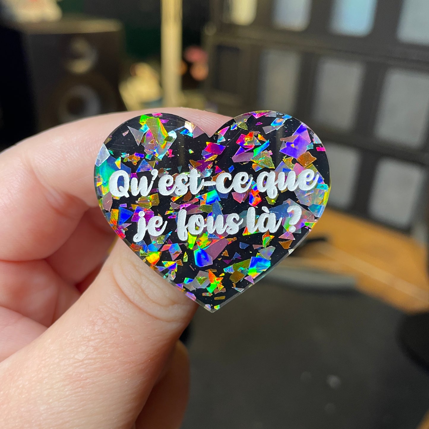 [Contrôle technique] Broche "Qu'est-ce que je fous là ?" en acrylique noire avec des éclats de confettis multicolores