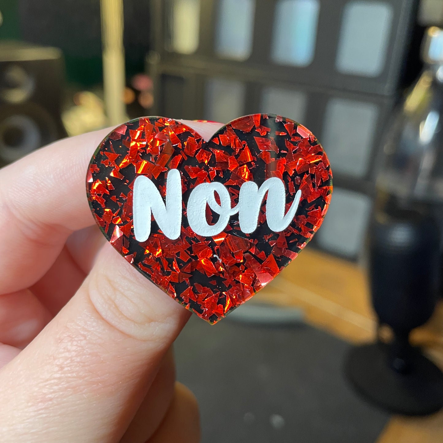 [Contrôle technique] Broche "Non" en acrylique noire avec des éclats de confettis rouges