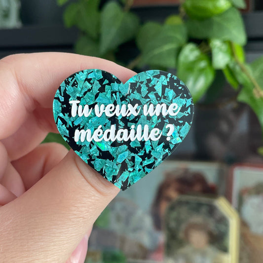 [CONTRÔLE TECHNIQUE] Broche "Tu veux une médaille ?" en acrylique noire avec des confettis turquoise