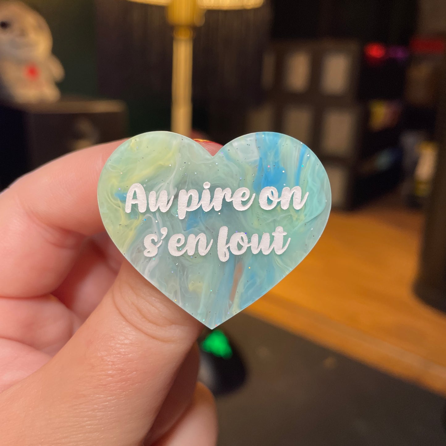 [Contrôle technique] Broche "Au pire on s'en fout" en acrylique semi transparente marbrée bleue, jaune et blanche à paillettes