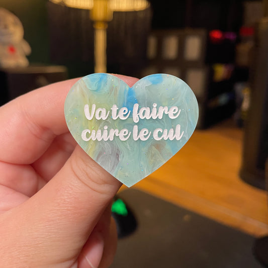 [Contrôle technique] Broche "Va te faire cuire le cul" en acrylique semi transparente marbrée bleue, jaune et blanche à paillettes