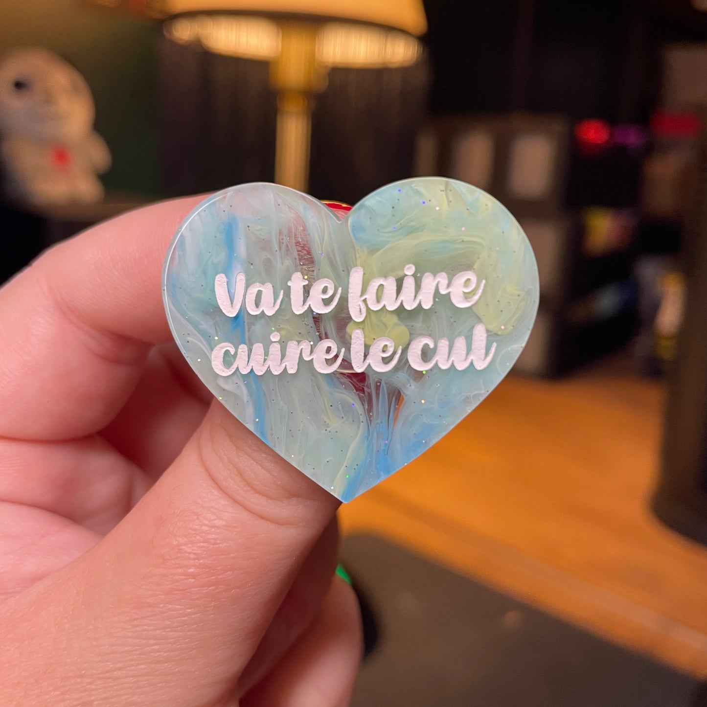 [Contrôle technique] Broche "Va te faire cuire le cul" en acrylique semi transparente marbrée bleue, jaune et blanche à paillettes