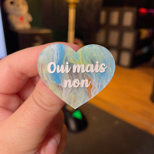 [Contrôle technique] Broche "Oui mais non" en acrylique semi transparente marbrée bleue, jaune et blanche à paillettes