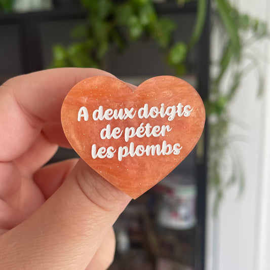 [CONTRÔLE TECHNIQUE] Broche "A deux doigts de péter les plombs" en acrylique marbrée orange pastel à paillettes