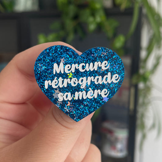 [CONTRÔLE TECHNIQUE] Broche "Mercure rétrograde sa mère" en acrylique bleue à paillettes avec des confettis étoiles