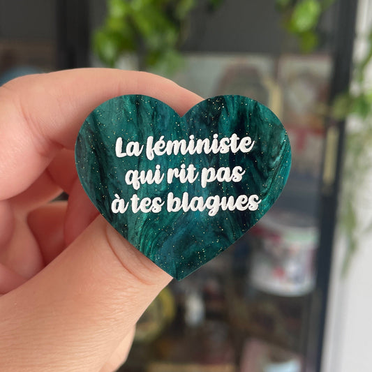[CONTRÔLE TECHNIQUE] Broche "La féministe qui rit pas à tes blagues" en acrylique marbrée noire et vert sapin à paillettes