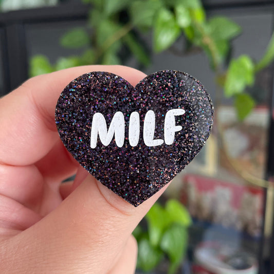 [CONTRÔLE TECHNIQUE] Broche "MILF" en acrylique à paillettes noires holographiques