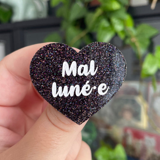 [INCLUSIF] Broche "Mal luné.e" en acrylique à paillettes noires holographiques