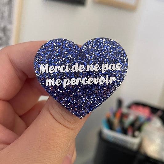 Broche "Merci de ne pas me percevoir" en acrylique à paillettes bleues et argentées