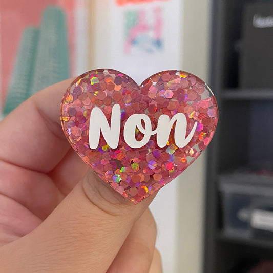 Broche "Non" en acrylique semi-transparente avec des confettis corail