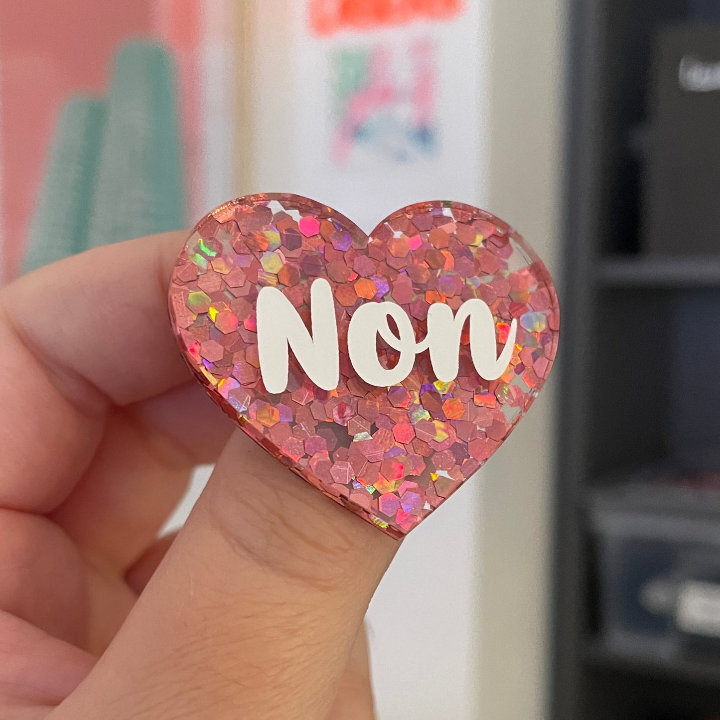 Broche "Non" en acrylique semi-transparente avec des confettis corail