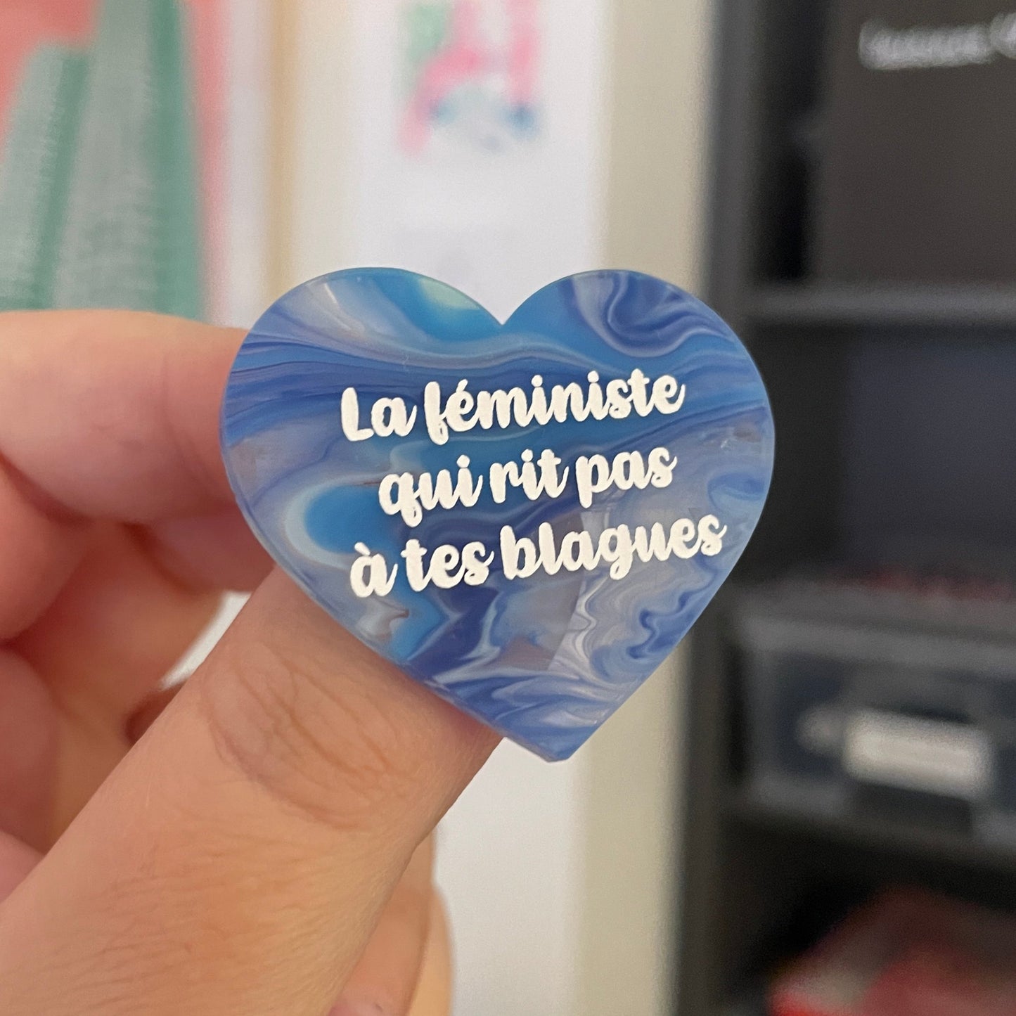 Broche "La féministe qui rit pas à tes blagues" en acrylique semi transparente marbrée bleue et blanche