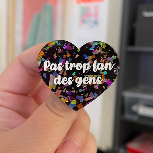 Broche "Pas trop fan des gens" en acrylique noire avec des éclats de confettis multicolores