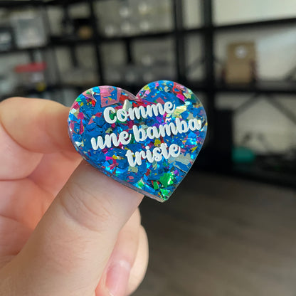 Broche "Comme une bamba triste" en acrylique transparente avec des éclats de confettis bleus et multicolores