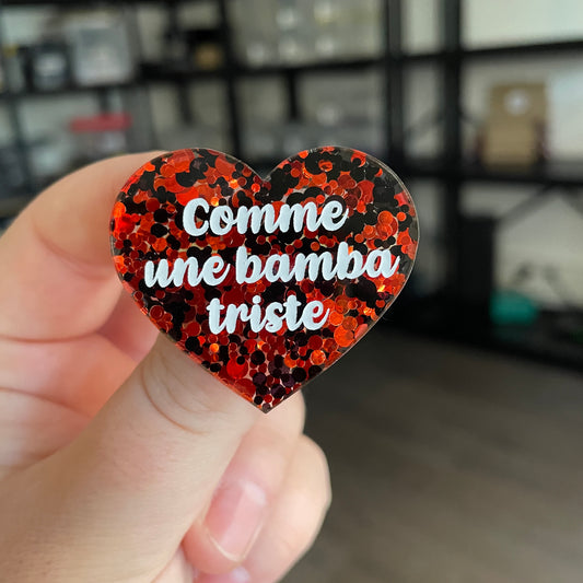 Broche "Comme une bamba triste" en acrylique semi transparente avec des pois rouges et noirs