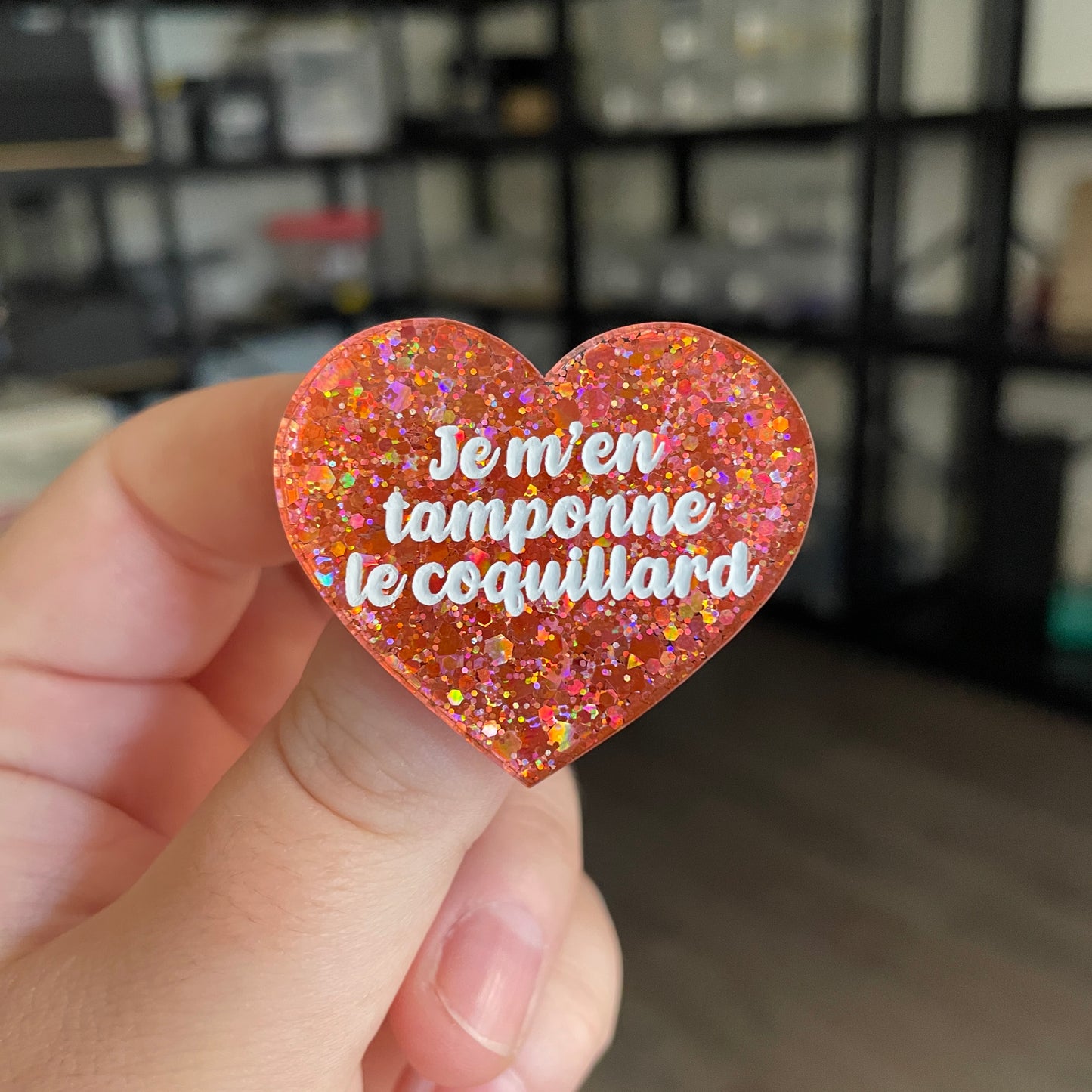 Broche "Je m'en tamponne le coquillard" en acrylique semi transparente à paillettes corail