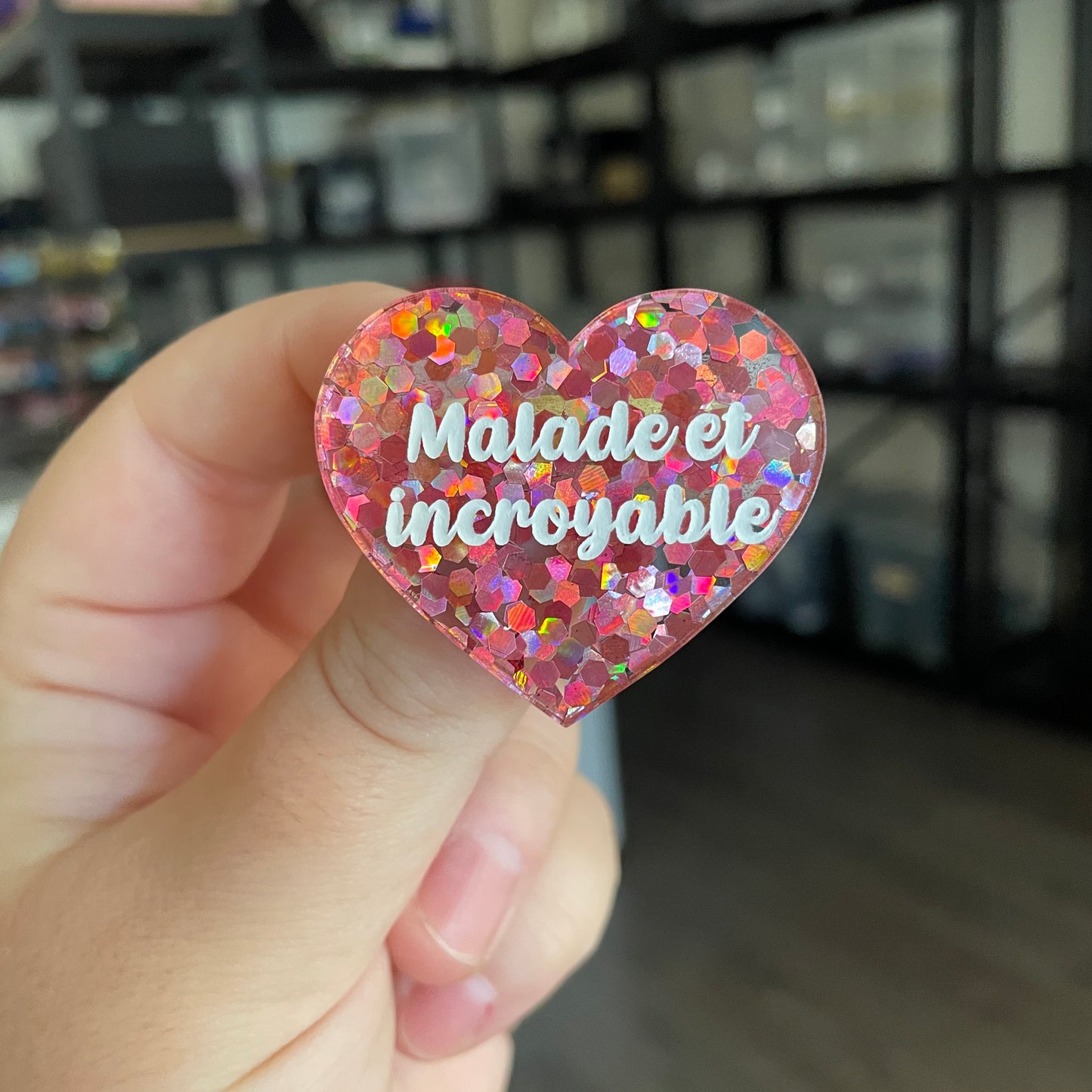 Broche "Malade et incroyable" en acrylique semi transparente avec des confettis corail
