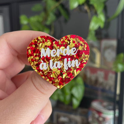 Broche "Merde à la fin" en acrylique à grosses paillettes rouges et jaunes