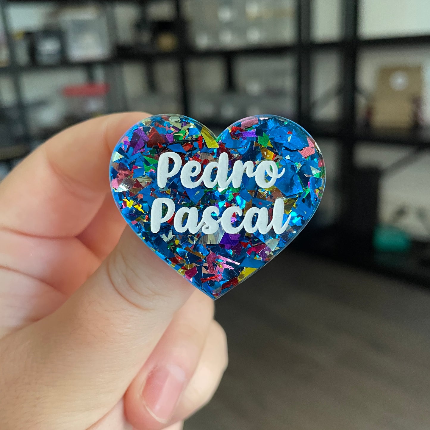 Broche "Pedro Pascal" en acrylique transparente avec des éclats de confettis bleus et multicolores