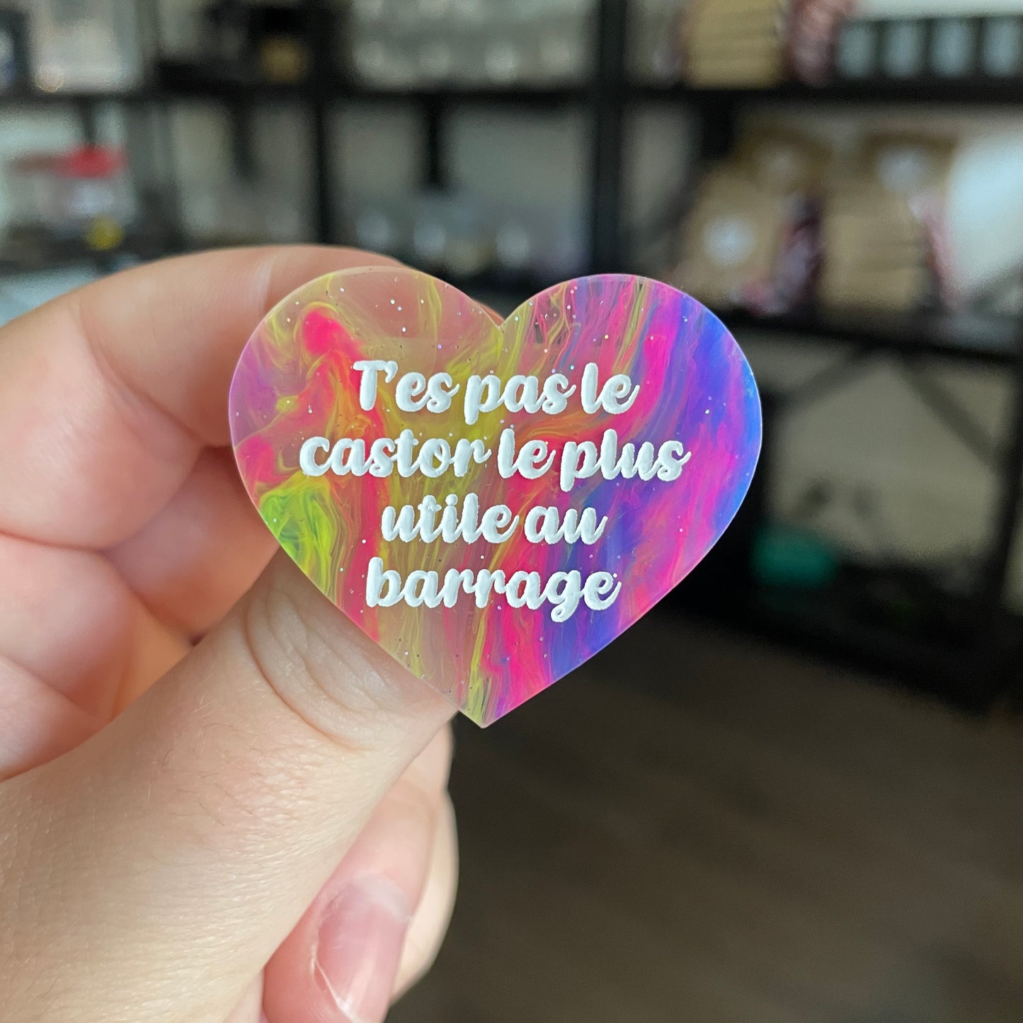 Broche "T'es pas le castor le plus utile au barrage" en acrylique semi transparente marbrée multicolore