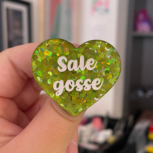 Broche "Sale gosse" en acrylique semi-transparente avec des confettis verts