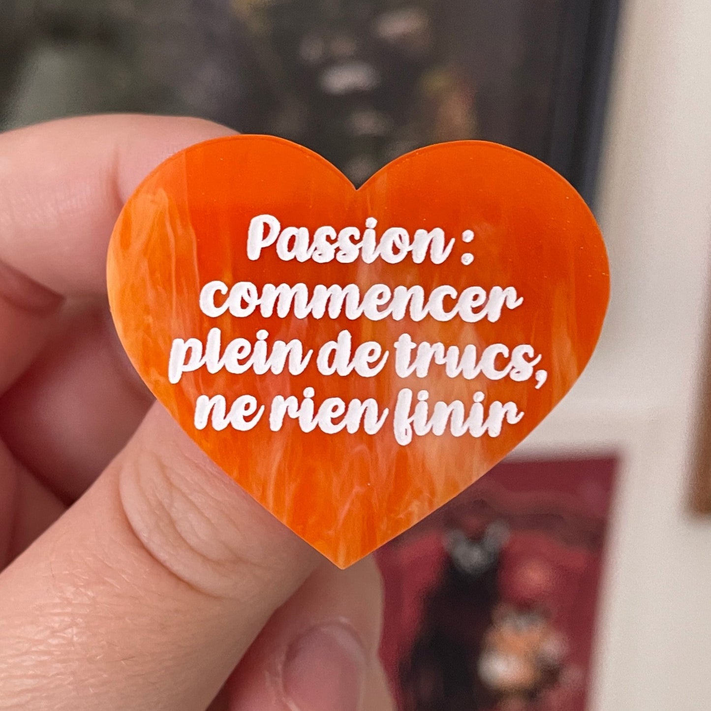 Broche "Passion : commencer plein de trucs, ne rien finir" en acrylique marbrée orange et dorée à paillettes