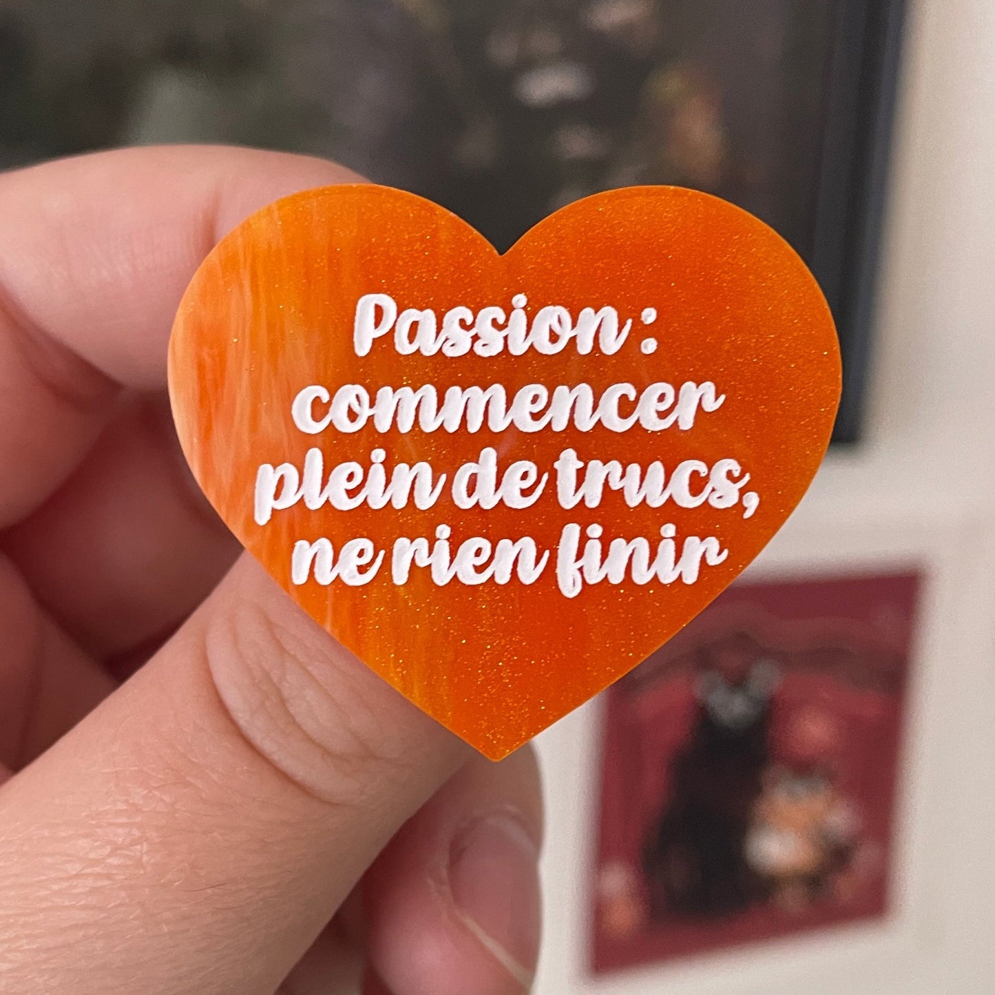 Broche "Passion : commencer plein de trucs, ne rien finir" en acrylique marbrée orange et dorée à paillettes