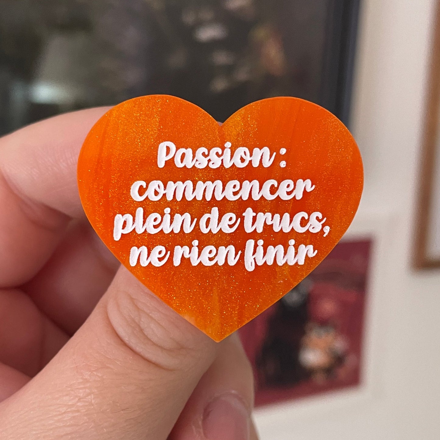 Broche "Passion : commencer plein de trucs, ne rien finir" en acrylique marbrée orange et dorée à paillettes