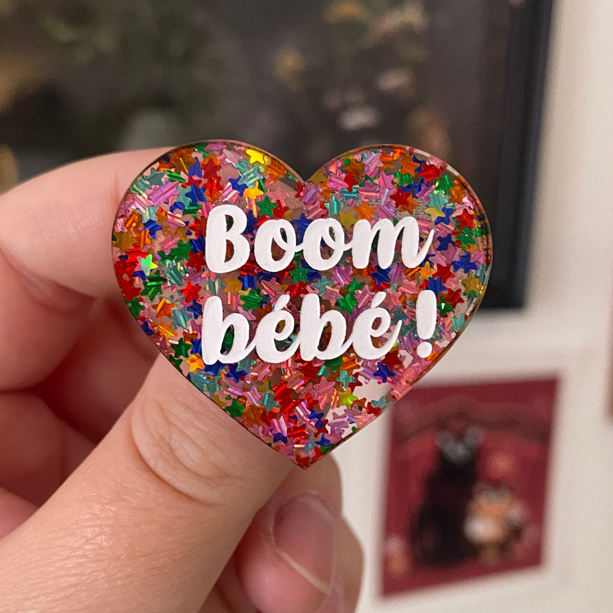 Broche "Boom bébé !" en acrylique semi-transparente avec des confettis étoiles multicolores