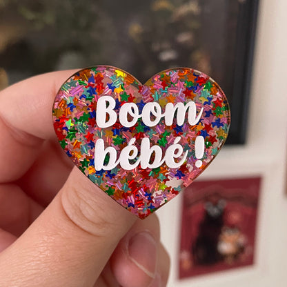 Broche "Boom bébé !" en acrylique semi-transparente avec des confettis étoiles multicolores