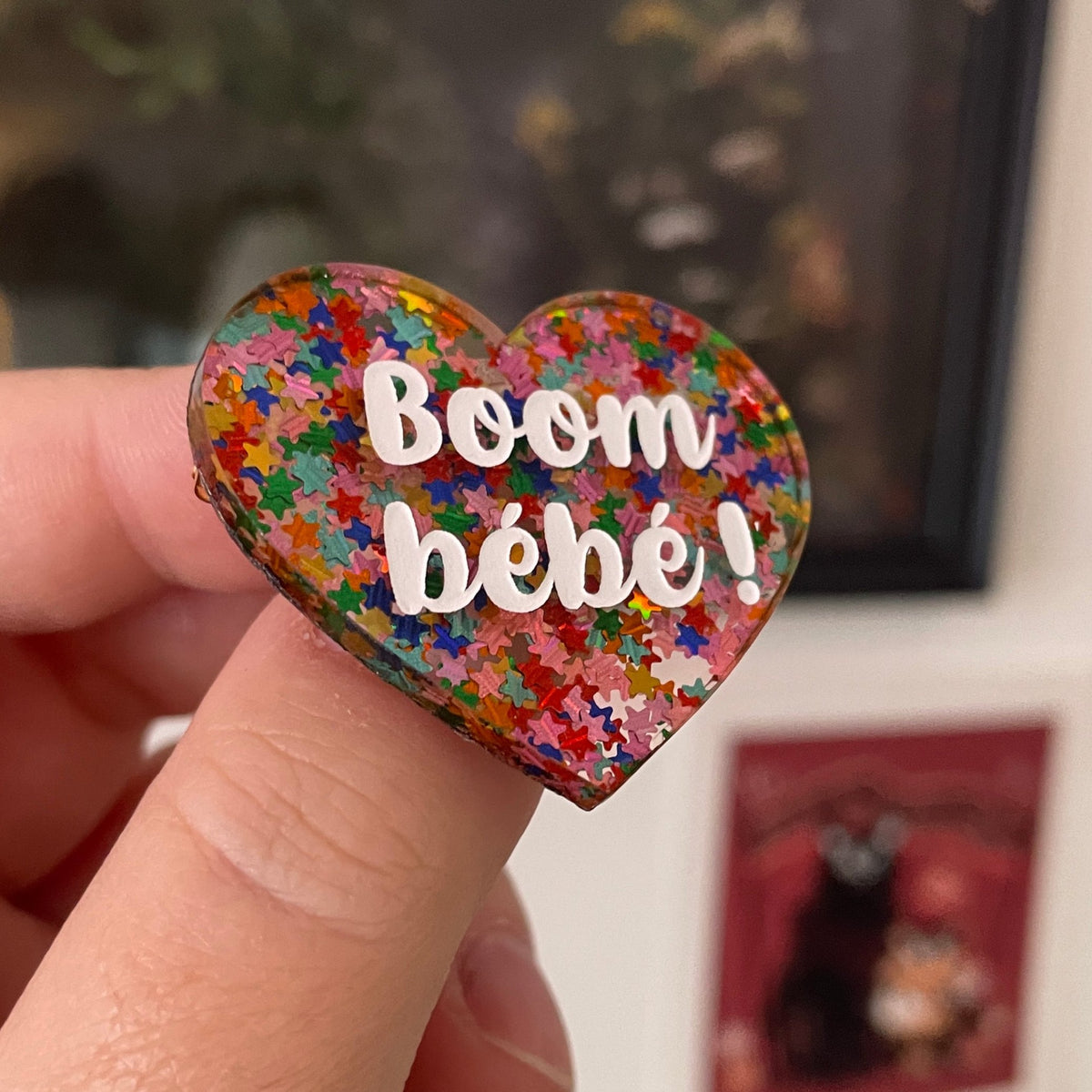 Broche "Boom bébé !" en acrylique semi-transparente avec des confettis étoiles multicolores