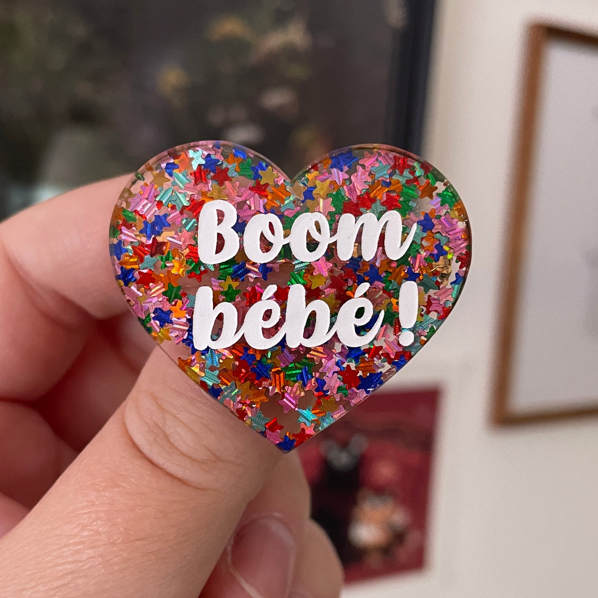Broche "Boom bébé !" en acrylique semi-transparente avec des confettis étoiles multicolores
