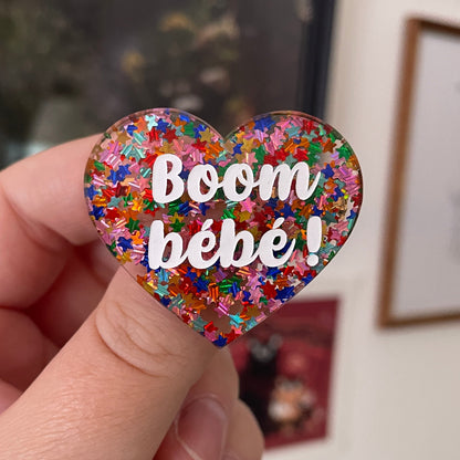 Broche "Boom bébé !" en acrylique semi-transparente avec des confettis étoiles multicolores