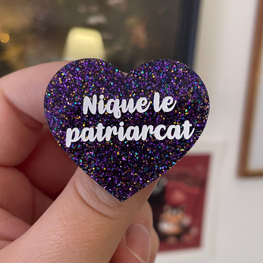 Broche "Nique le patriarcat" en acrylique à paillettes violettes, bleues et jaunes