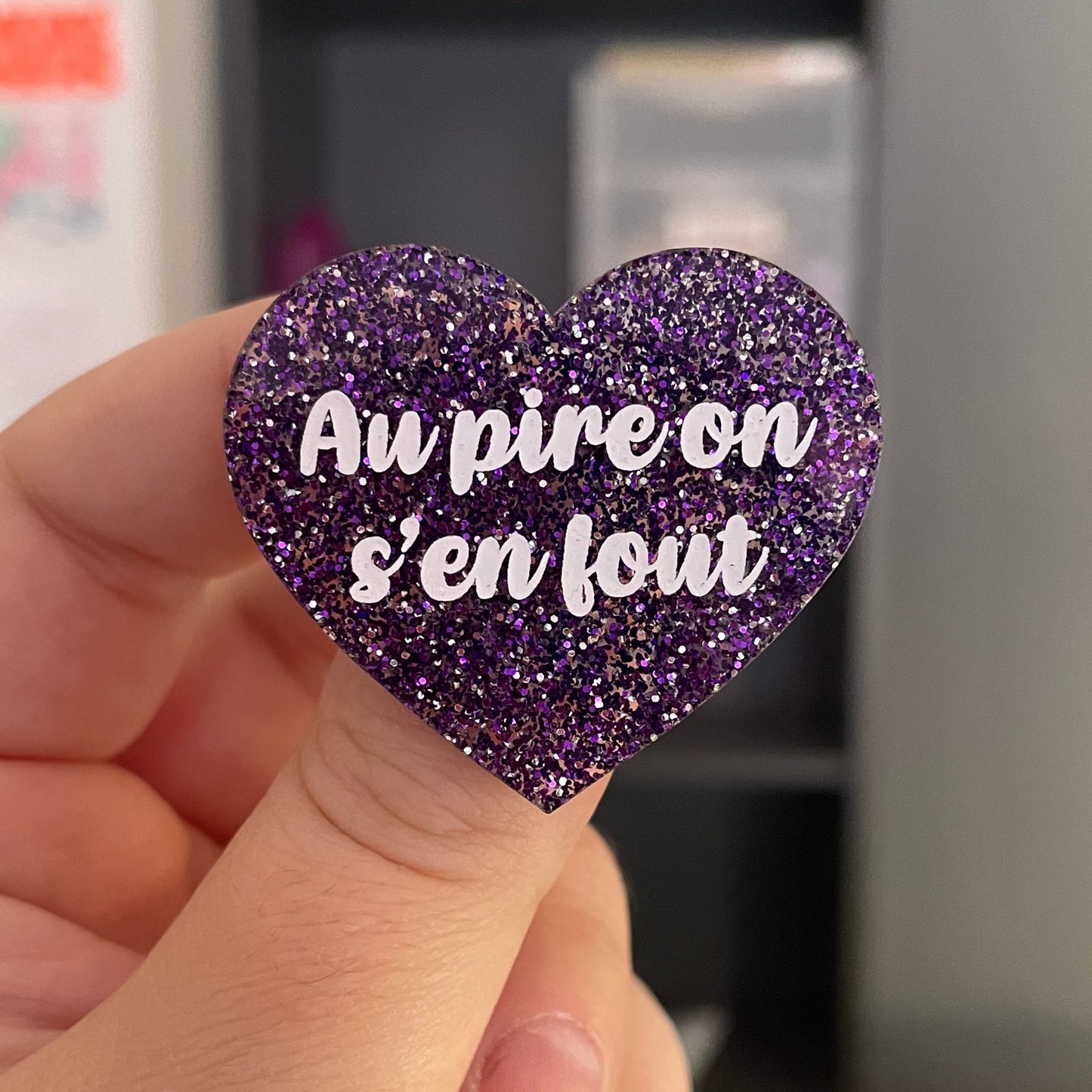 Broche "Au pire on s'en fout" en acrylique à paillettes violettes et argentées