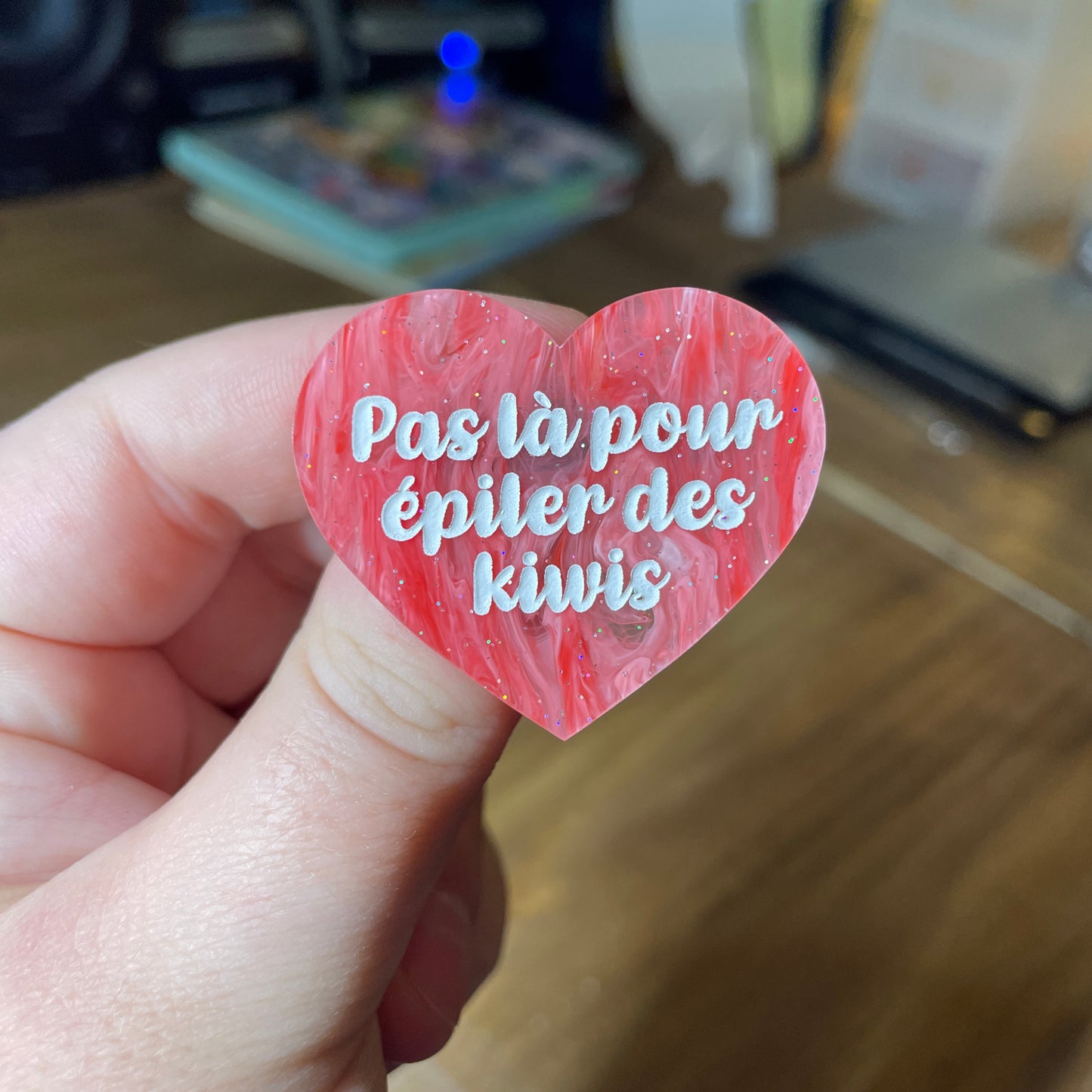 Broche "Pas là pour épiler des kiwis" en acrylique semi transparente marbrée rouge, rose et blanche à paillettes