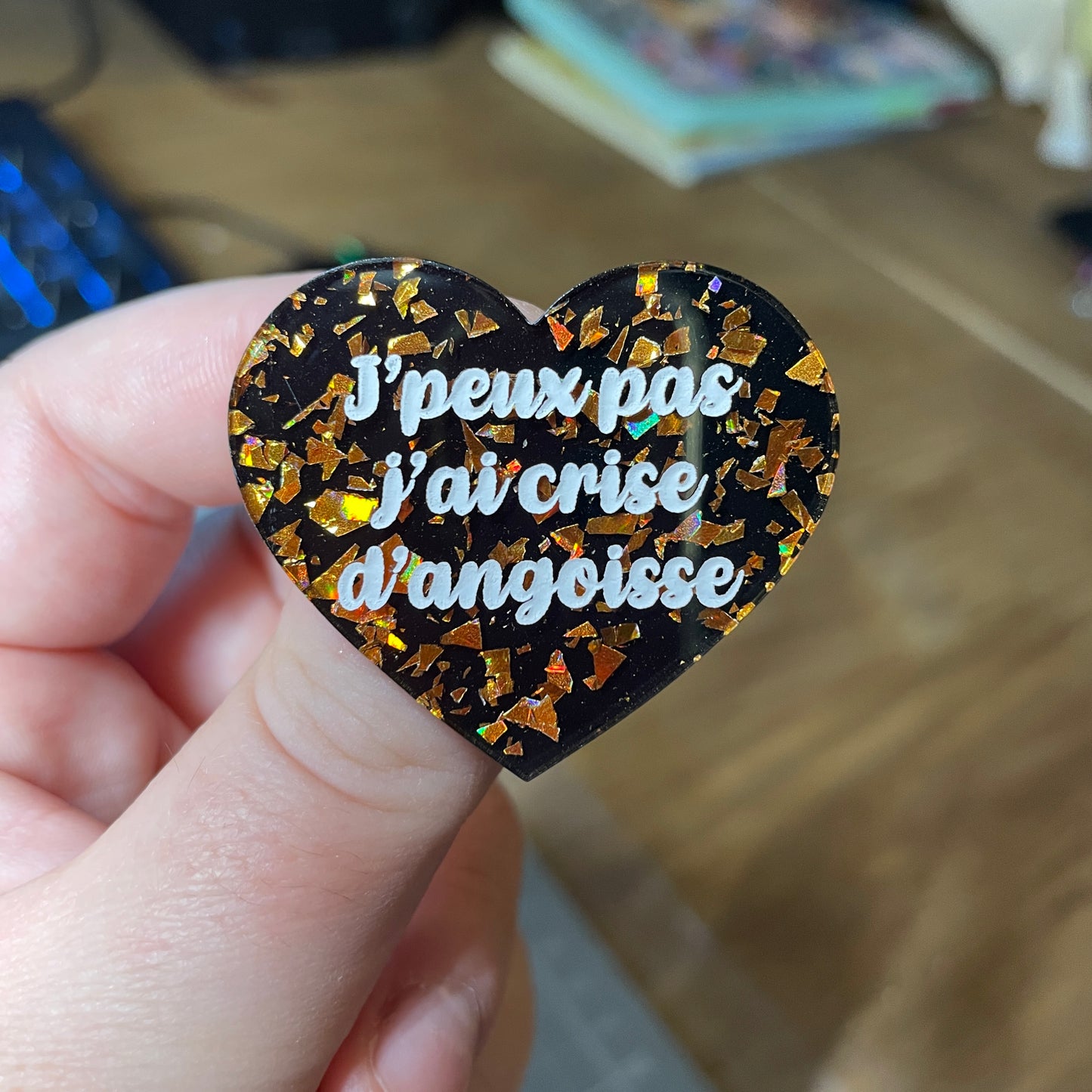 Broche "J'peux pas j'ai crise d'angoisse" en acrylique noire avec des éclats de confettis oranges