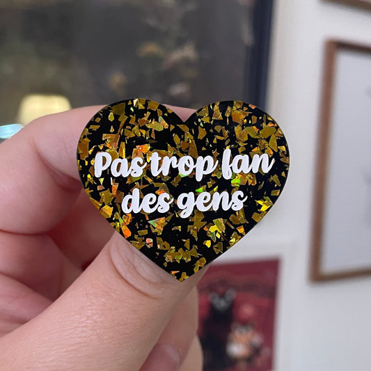 [CONTRÔLE TECHNIQUE] Broche "Pas trop fan des gens" en acrylique noir avec des éclats de confettis doré vif