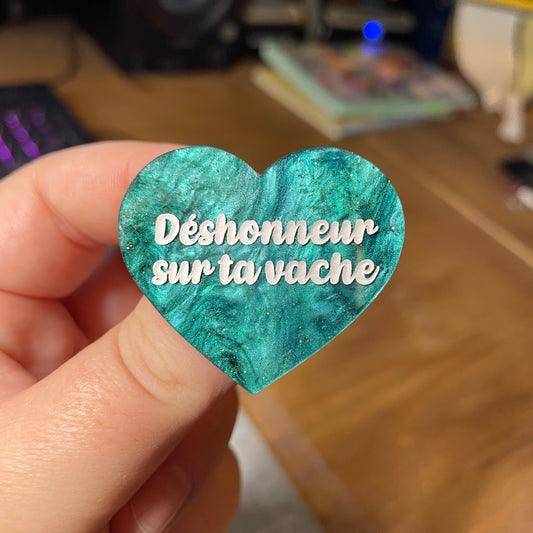 Broche "Déshonneur sur ta vache" en acrylique marbrée verte et noire à paillettes