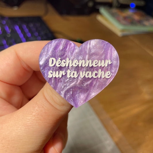 Broche "Déshonneur sur ta vache" en acrylique marbrée bleue, violette et blanche à paillettes