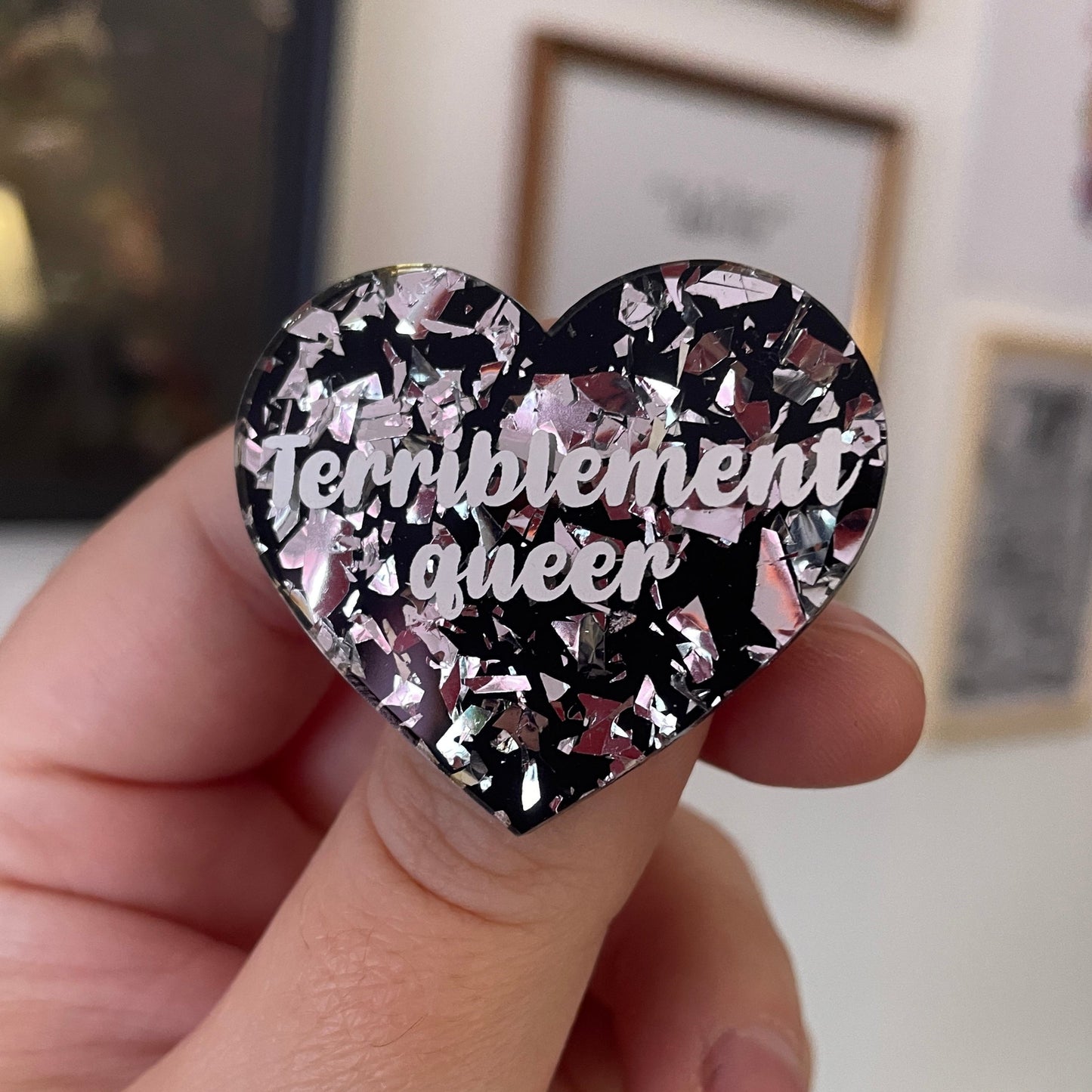 [CONTRÔLE TECHNIQUE] Broche "Terriblement queer" en acrylique noire avec des confettis argentés