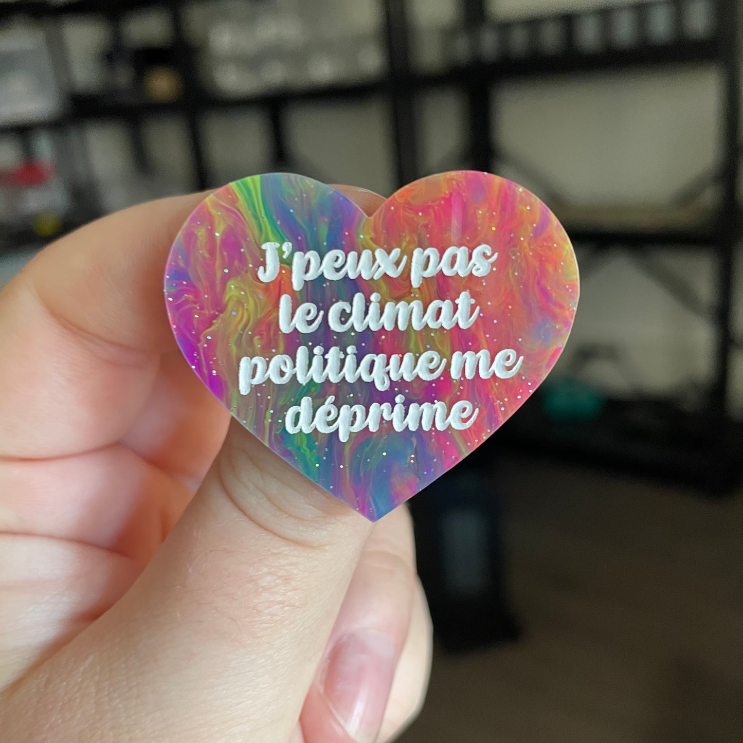 Broche "J'peux pas, le climat politique me déprime" en acrylique semi transparente marbrée multicolore
