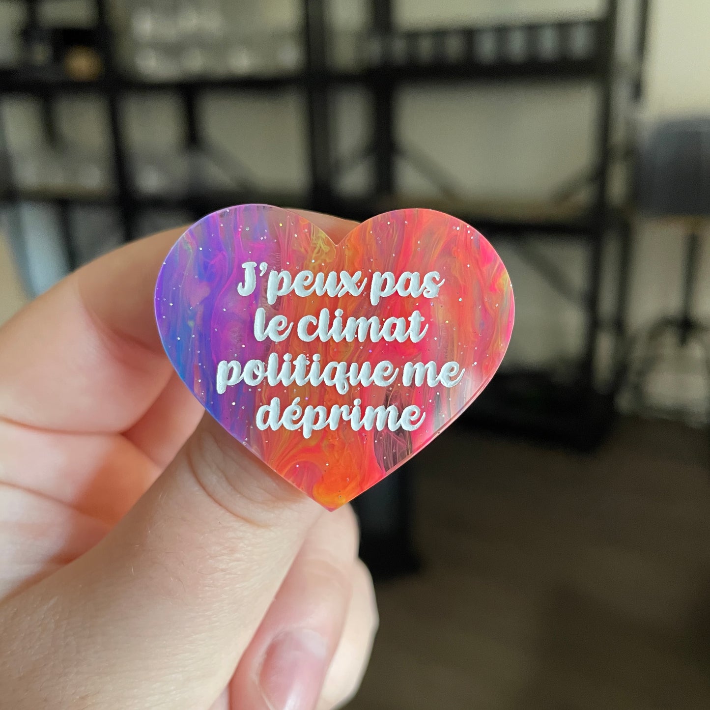 Broche "J'peux pas le climat politique me déprime" en acrylique semi transparente marbrée multicolore