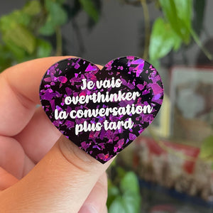 Broche "Je vais overthinker la conversation plus tard" en acrylique noire avec des éclats de confettis violets
