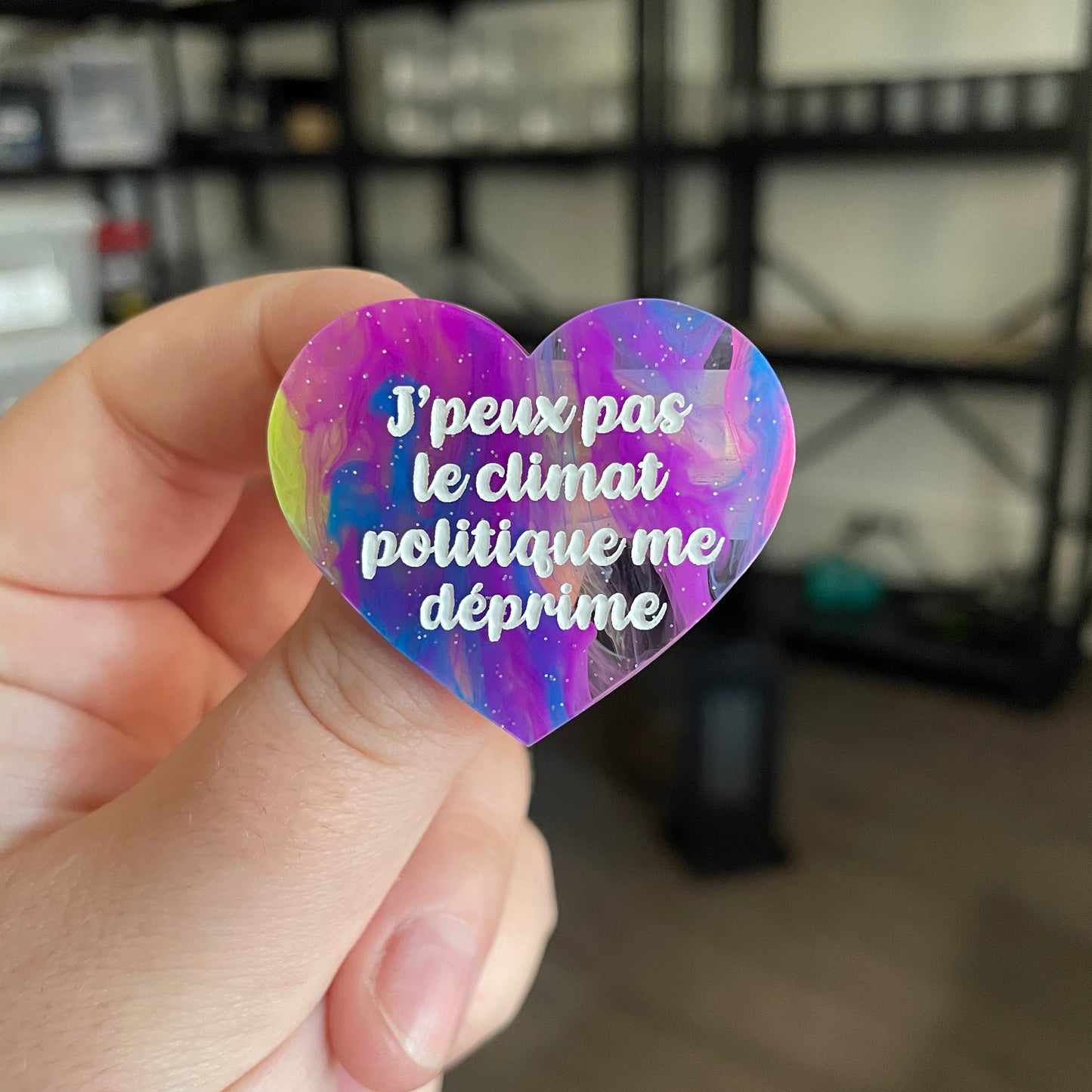 Broche "J'peux pas le climat politique me déprime" en acrylique semi transparente marbrée multicolore