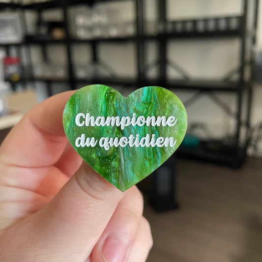 Broche "Championne du quotidien" en acrylique marbrée verte à paillettes