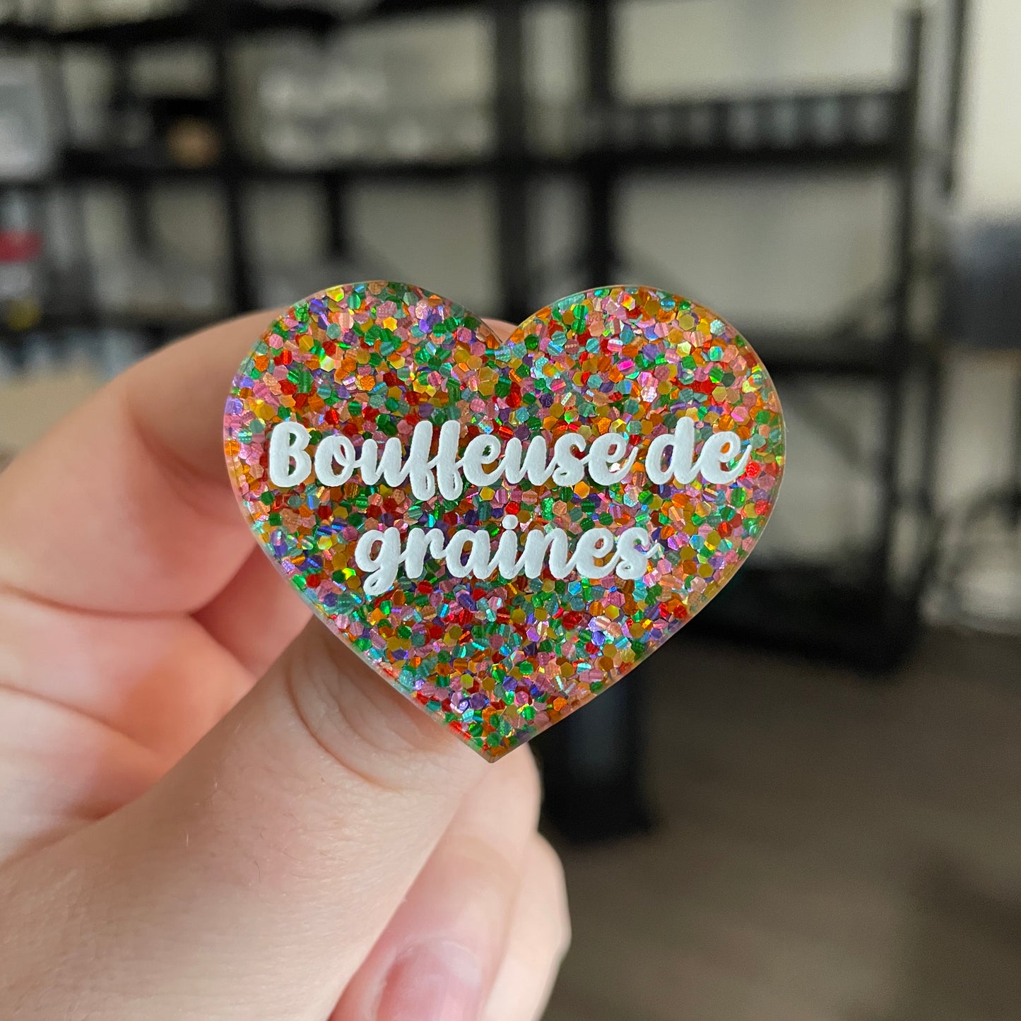 Broche "Bouffeuse de graines" en acrylique semi transparente avec des pois multicolores